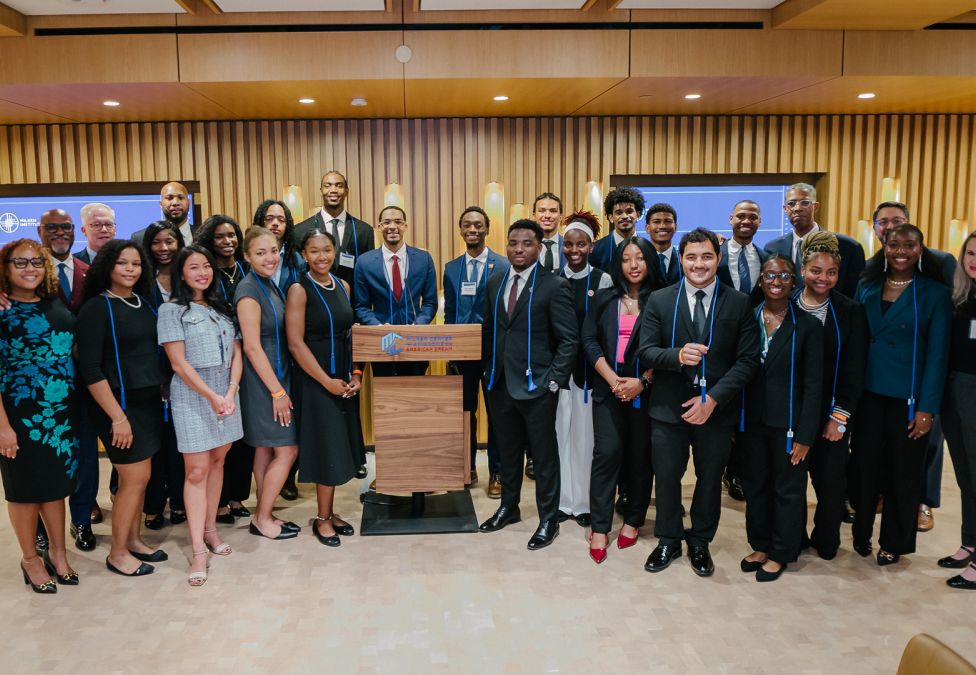 Large diverse group of professionals posing together in a modern conference room with wood paneling